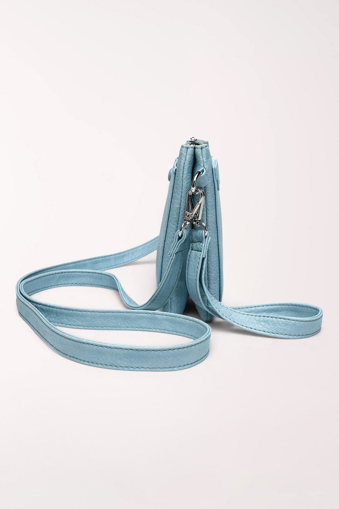 Side view of the baby blue 22 Tote Two-Sided Crossbody Bag showing its two separate zip compartments and strap.