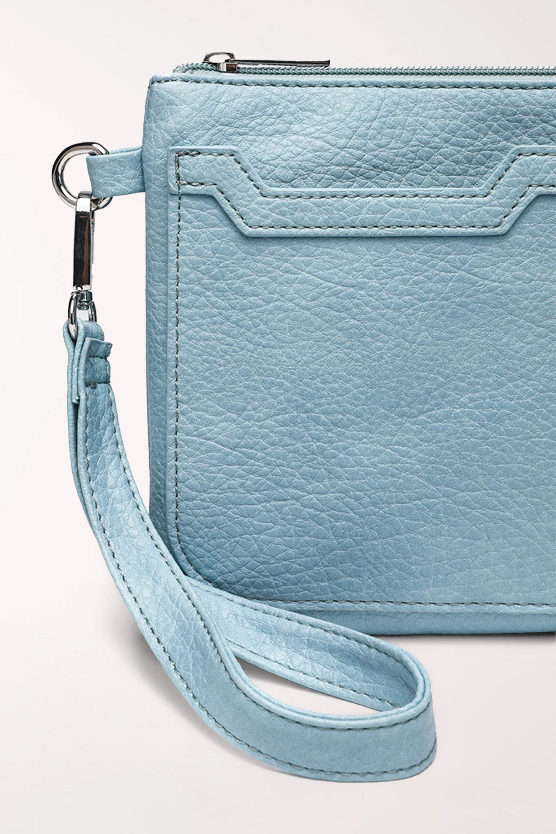 Close-up of the baby blue 22 Tote Two-Sided Crossbody Bag showing the stitched slip pocket detail, top zipper and strap clip.