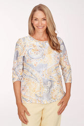 Woman wearing a patterned top with a plain background