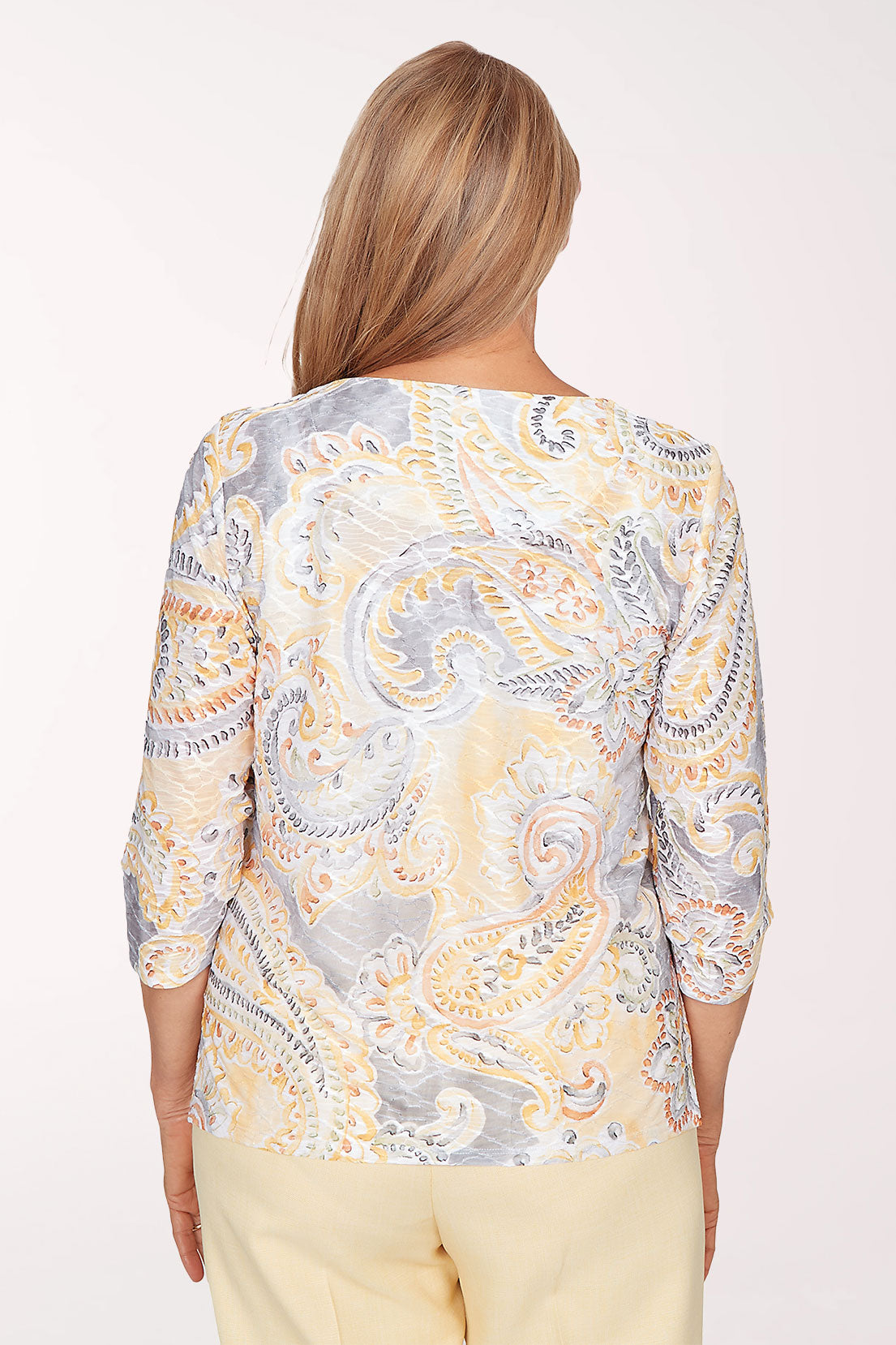 Woman wearing a patterned top with a plain background