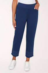 Navy blue pants with white sneakers on a light pink background