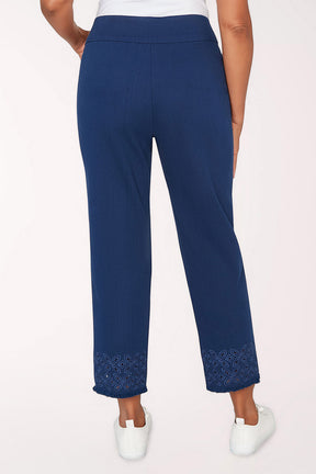 Navy blue pants with white sneakers on a light pink background