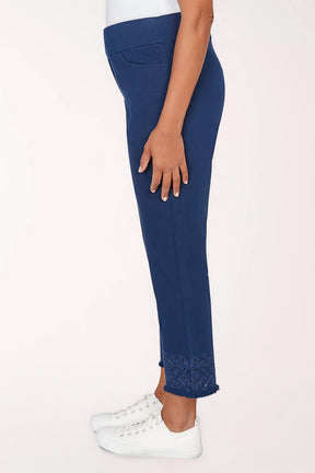 Navy blue pants with white sneakers on a light pink background