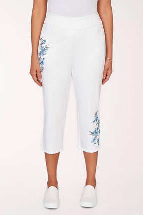 White capri pants with floral embroidery on a white background