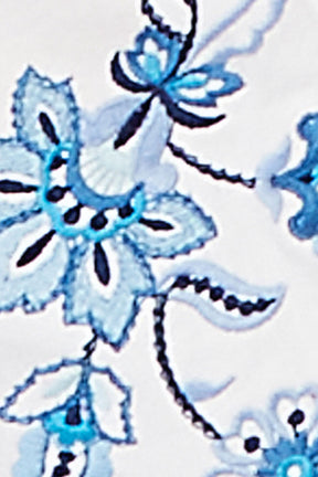 Close-up of blue floral embroidery on white fabric