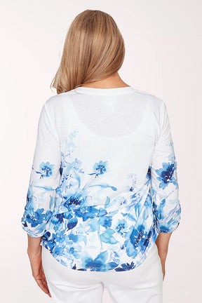 Woman wearing a white blouse with blue floral pattern on a white background