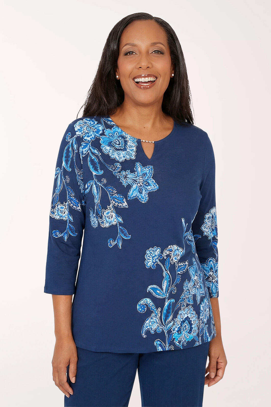 Woman wearing a blue floral patterned top against a white background