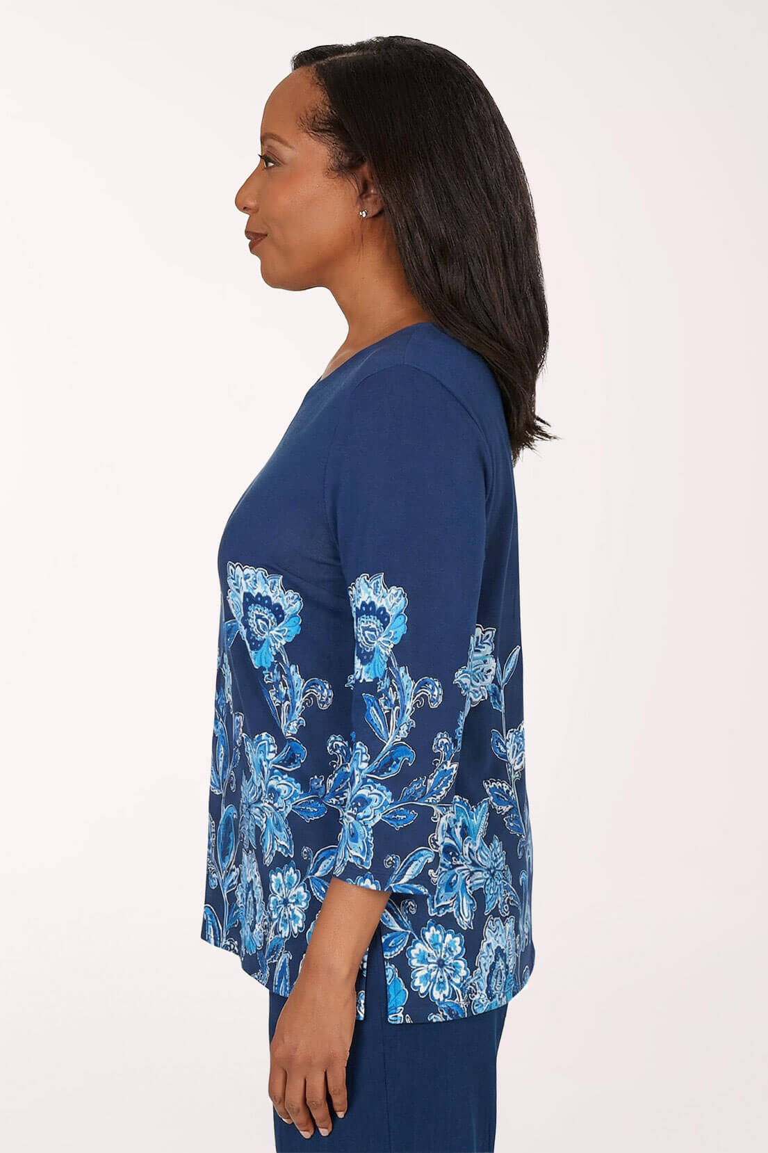 Woman wearing a blue floral patterned top against a white background