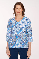Woman wearing a blue and white patterned blouse on a white background