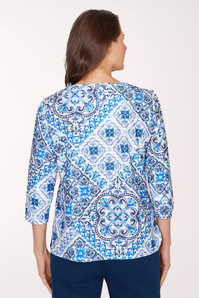 Woman wearing a blue and white patterned blouse on a white background