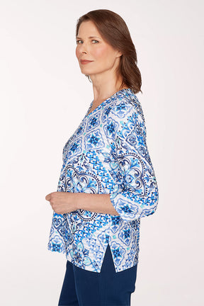 Woman wearing a blue and white patterned blouse on a white background