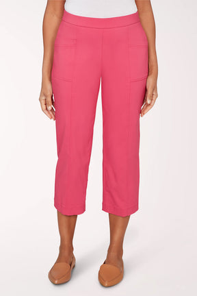 Person wearing bright pink capri pants on a white background