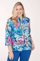 Woman wearing a colorful floral blouse with a white background