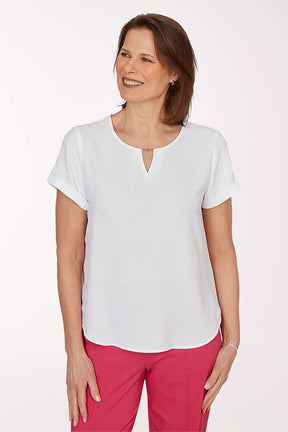 Woman wearing a white blouse and pink pants on a white background
