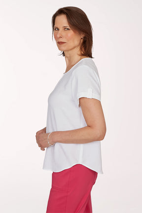 Woman wearing a white blouse and pink pants on a white background