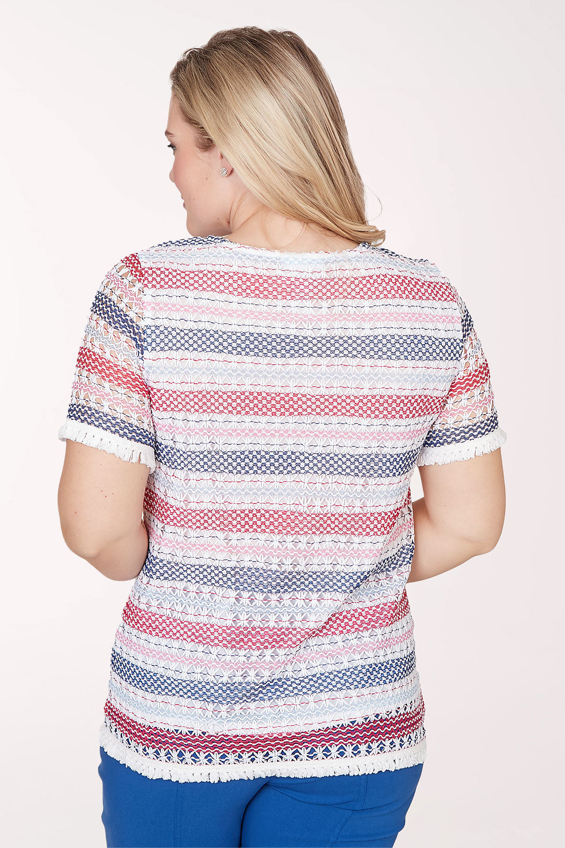 Woman wearing a patterned top with buttons on a white background