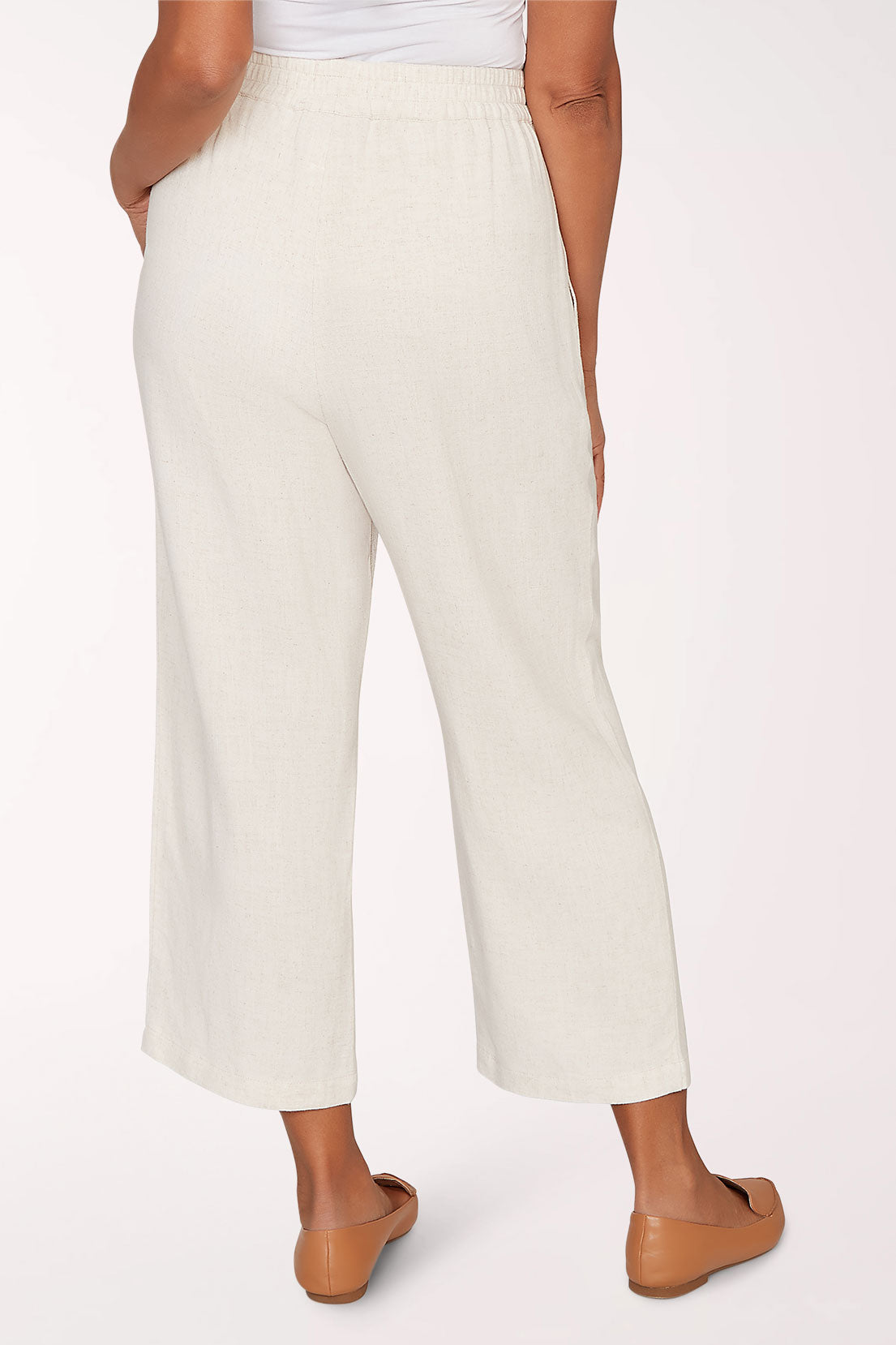 Person wearing white pants on a plain background