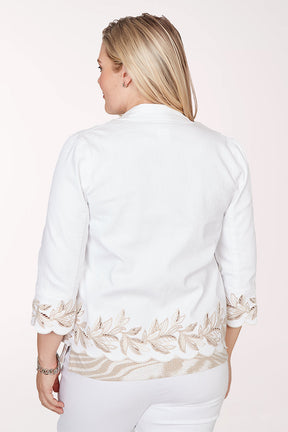 Woman wearing a white jacket with floral patterns on a light pink background