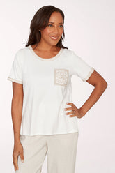 Woman wearing a white t-shirt with a square design on a plain background