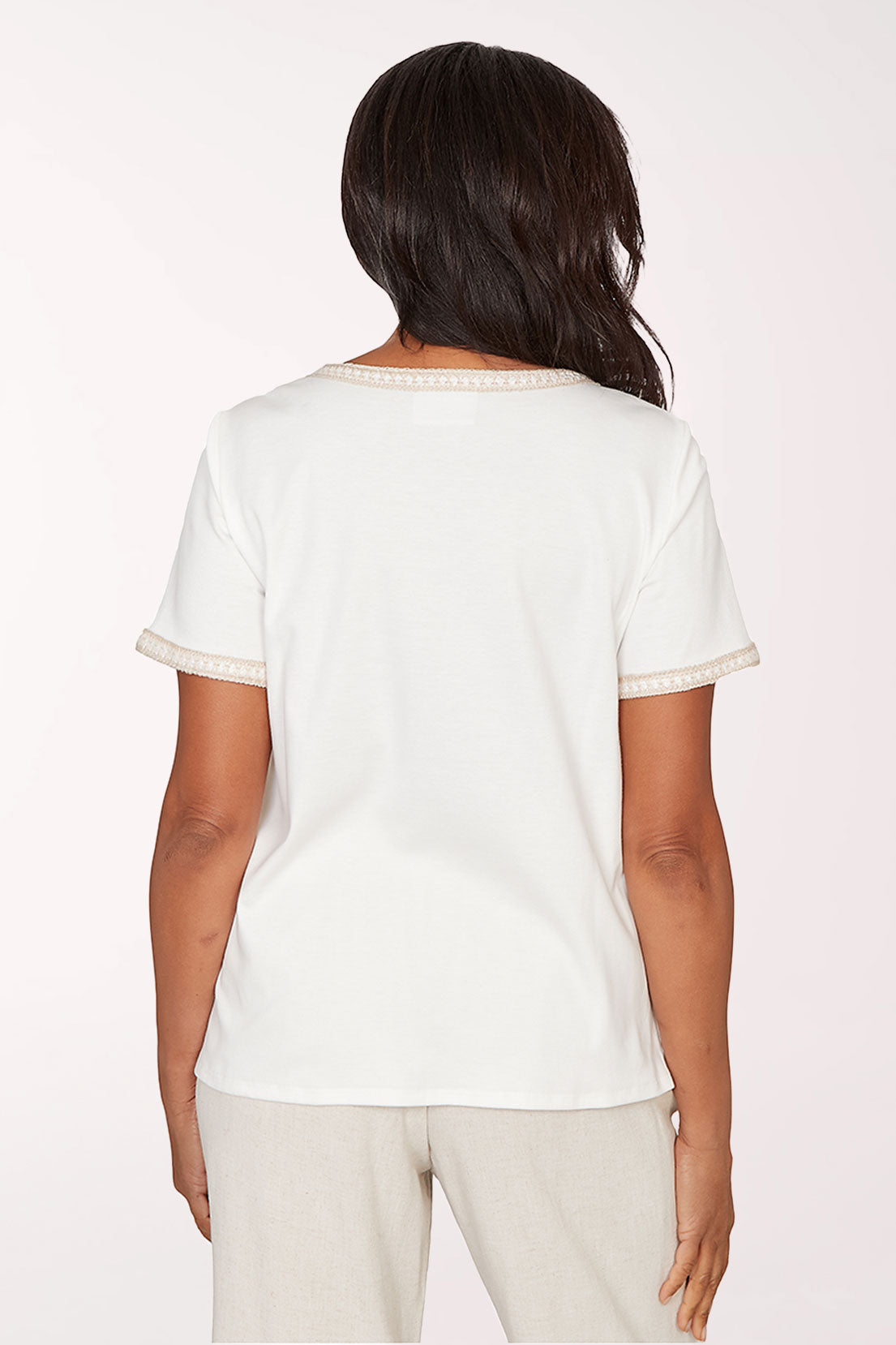 Woman wearing a white t-shirt with a square design on a plain background