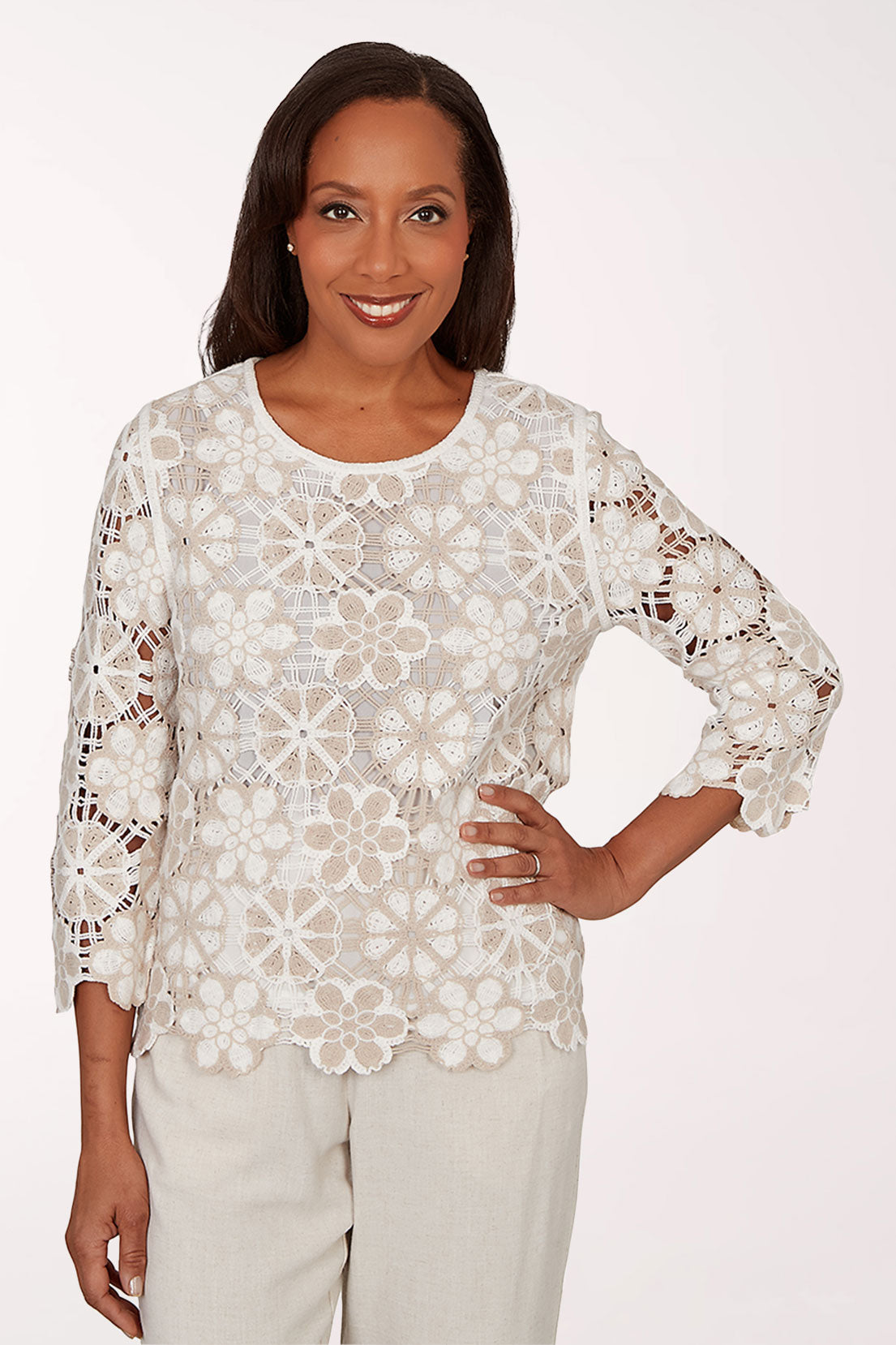 Woman wearing a white lace top with a plain background