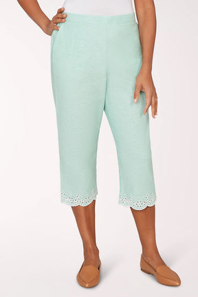 Mint green capri pants with lace trim worn by a person on a white background