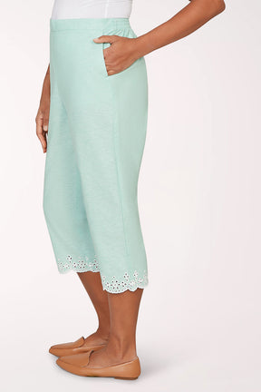 Mint green capri pants with lace trim worn by a person on a white background