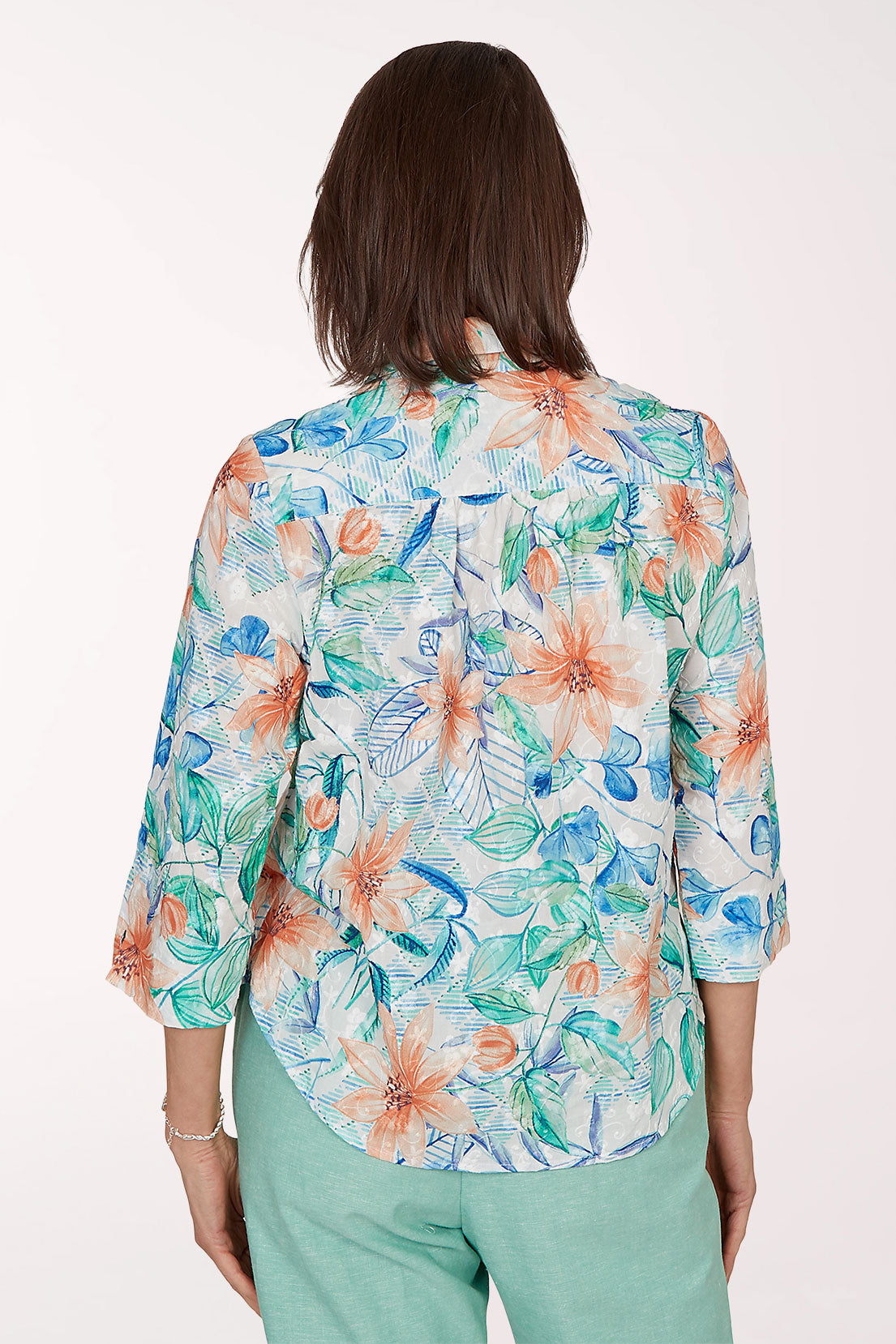 Woman wearing a colorful floral blouse with a white background