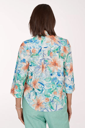 Woman wearing a colorful floral blouse with a white background