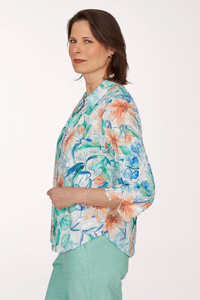 Woman wearing a colorful floral blouse with a white background
