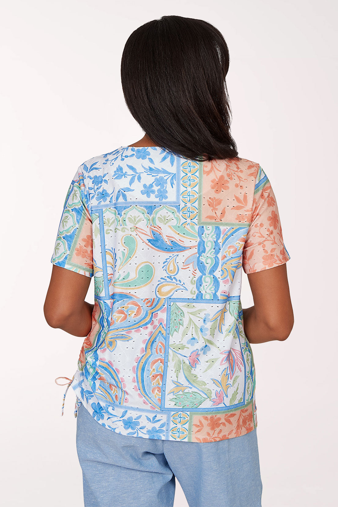 Woman wearing a colorful patterned top with a white background