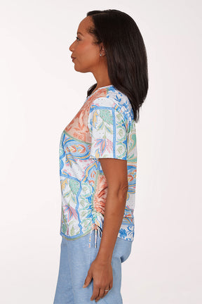 Woman wearing a colorful patterned top with a white background