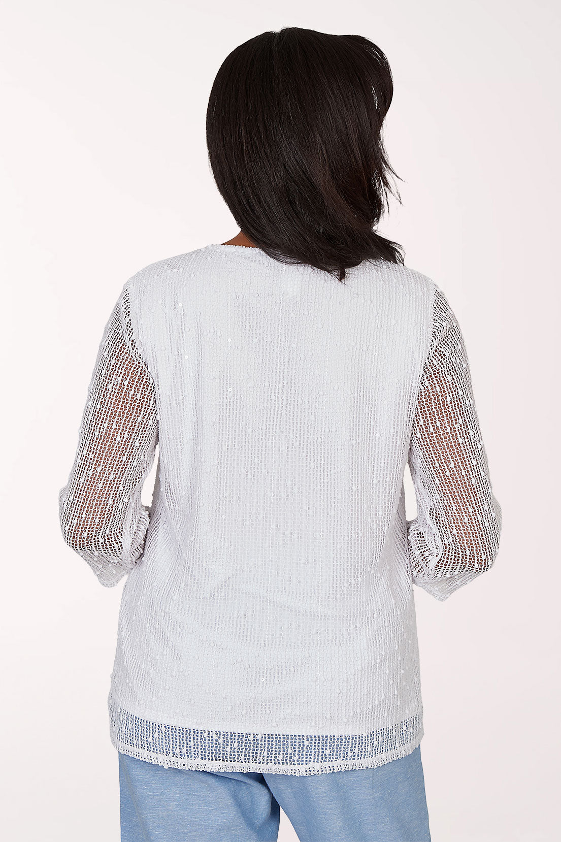 Woman wearing a white top with sheer sleeves on a white background