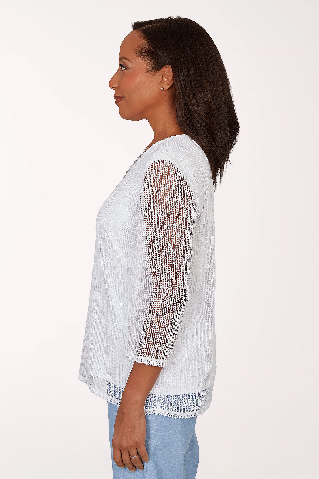 Woman wearing a white top with sheer sleeves on a white background