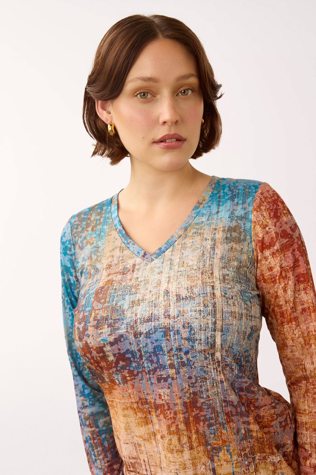 Woman wearing a 3/4 sleeve multicolored v-neck top 
