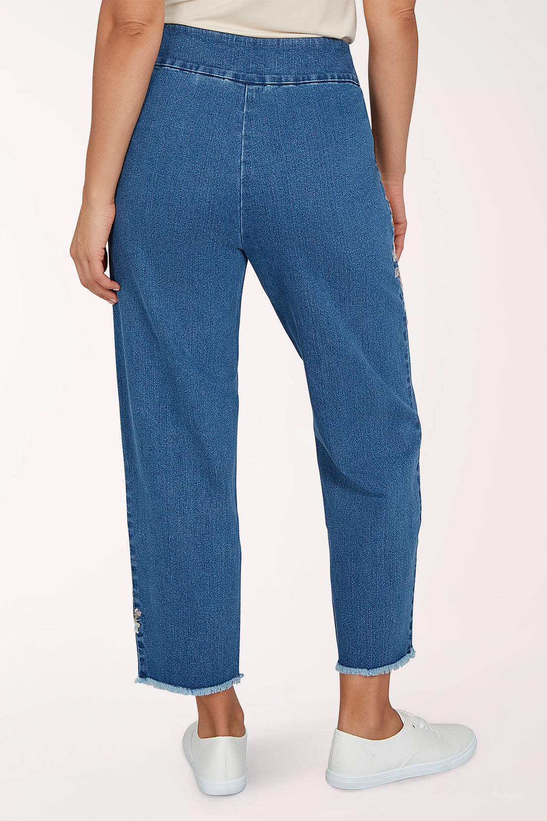Woman wearing a denim crop pant with a floral design