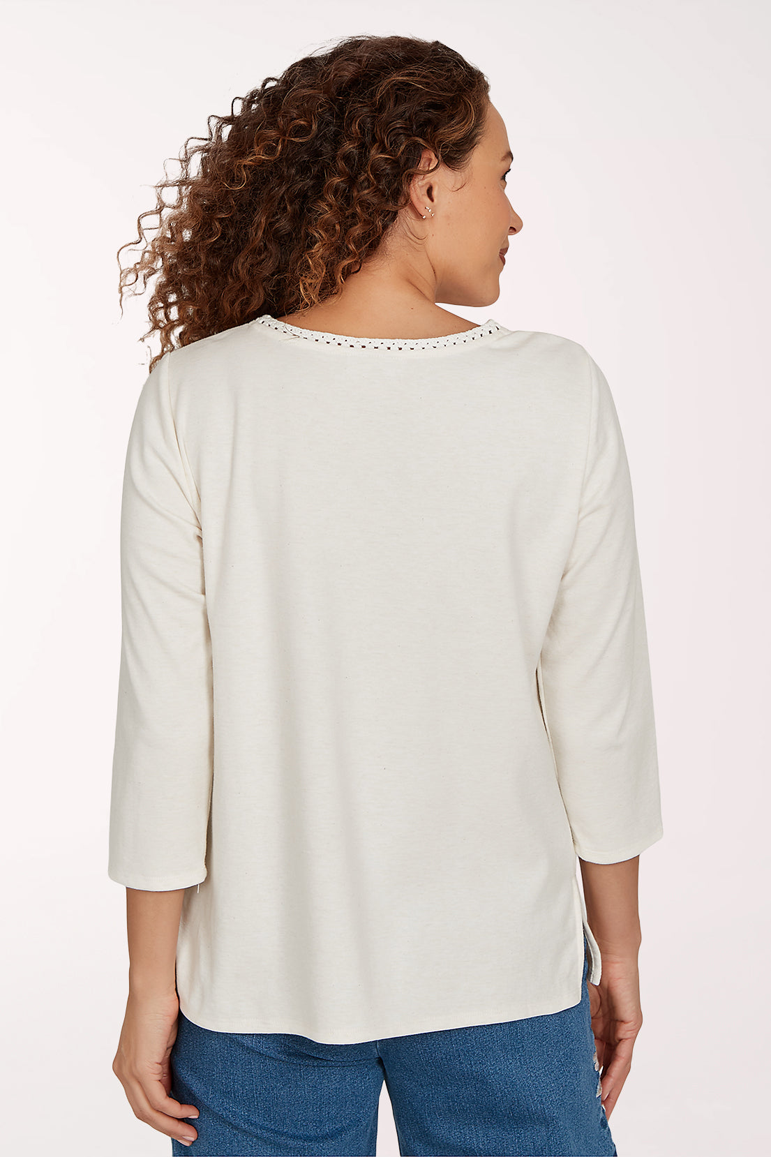 Woman wearing a white crochet top with a floral design