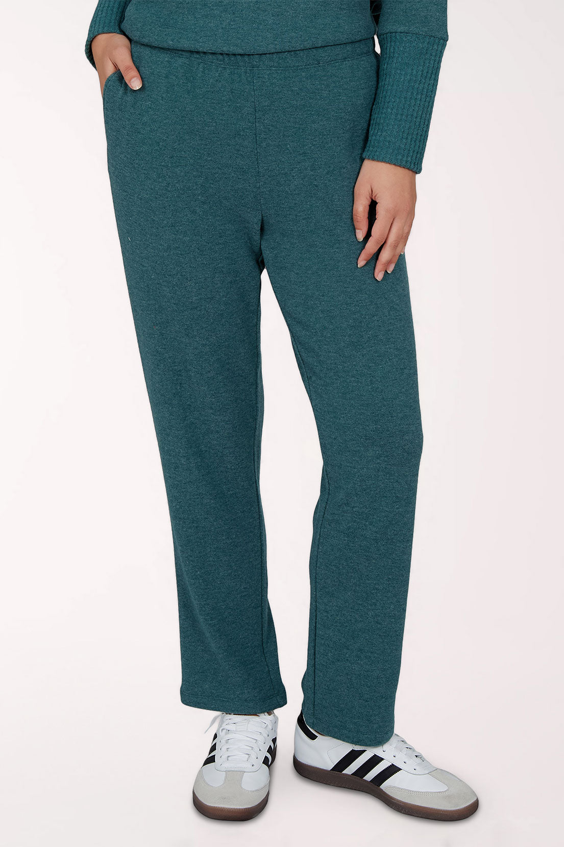 A person wearing heathered teal lounge pants with a matching long-sleeve top and white sneakers, shown from the waist down against a plain light background.