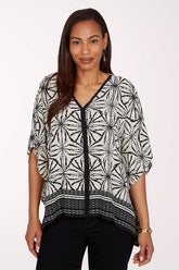 Woman wearing a black and white patterned top on a white background