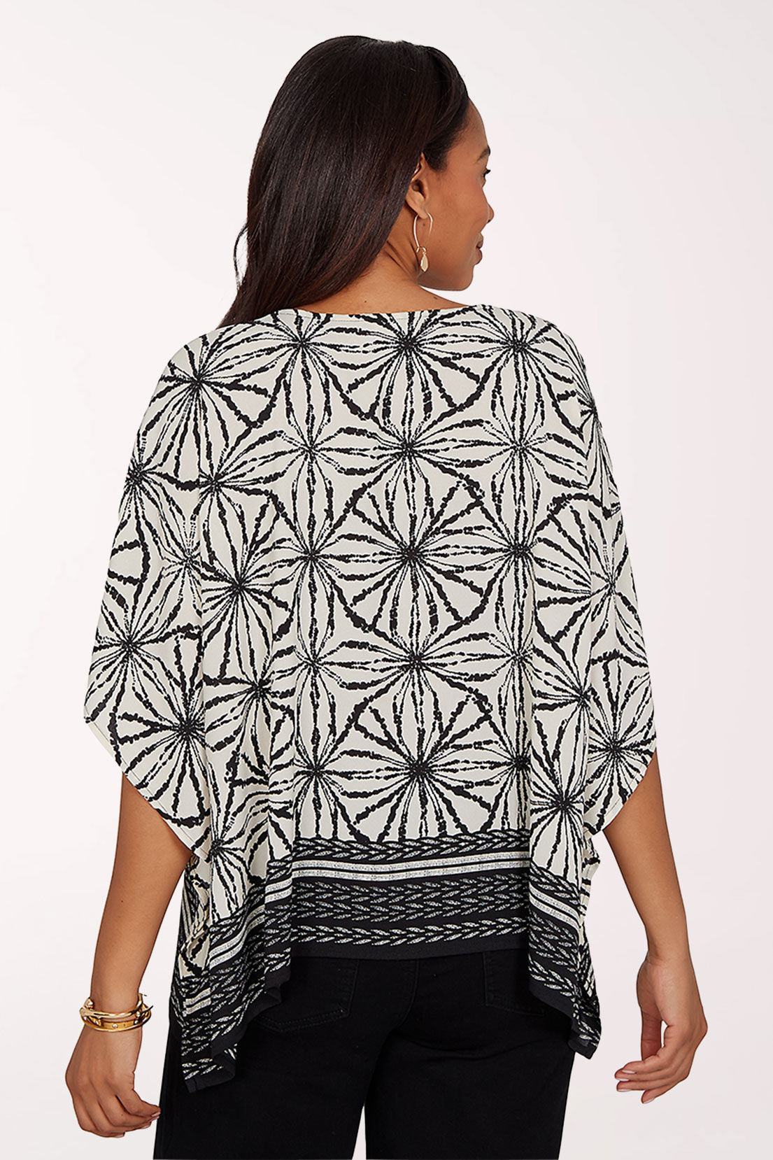 Woman wearing a black and white patterned top on a white background