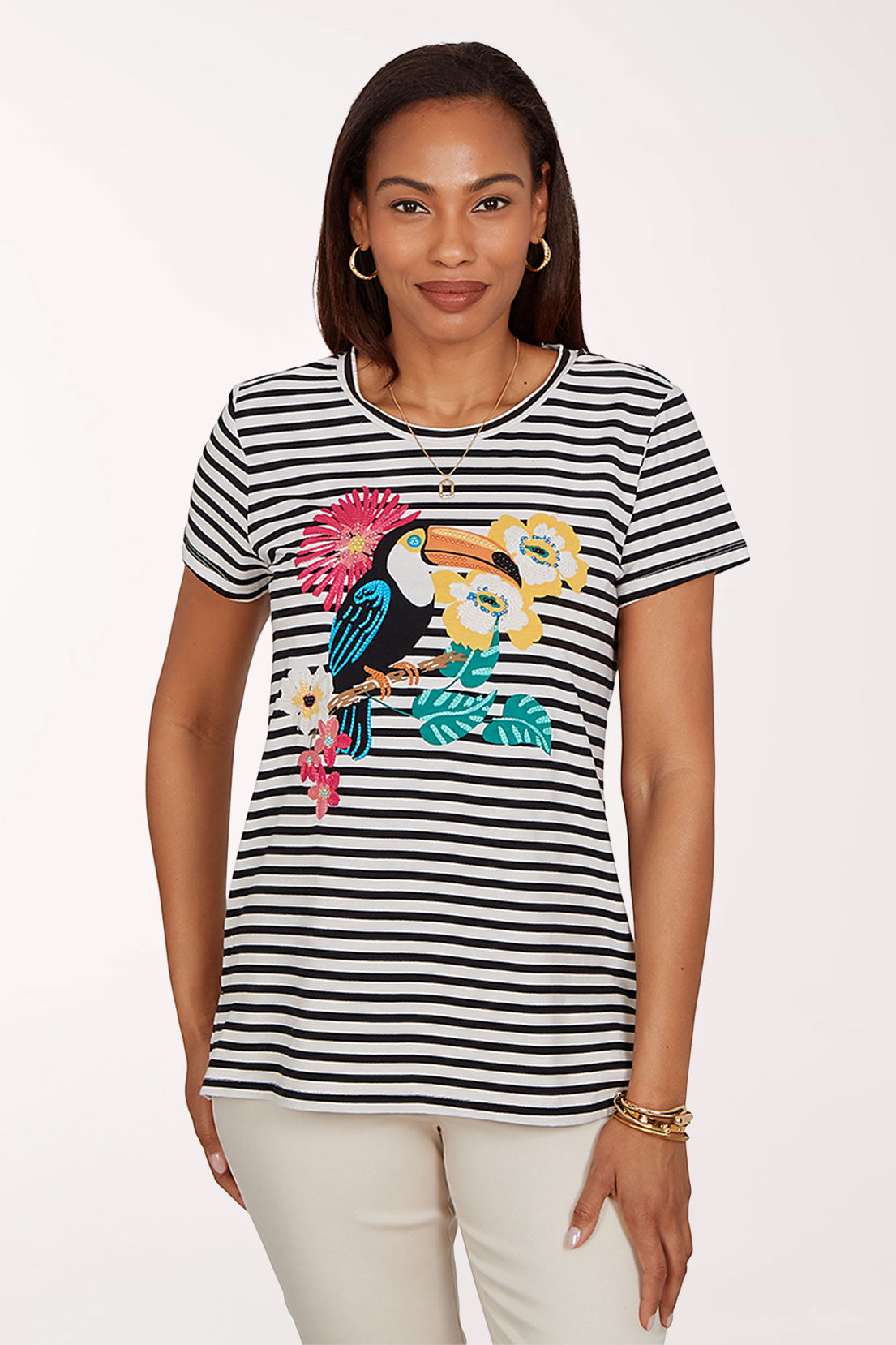 Woman wearing a black and white striped t-shirt with a colorful toucan design on a white background