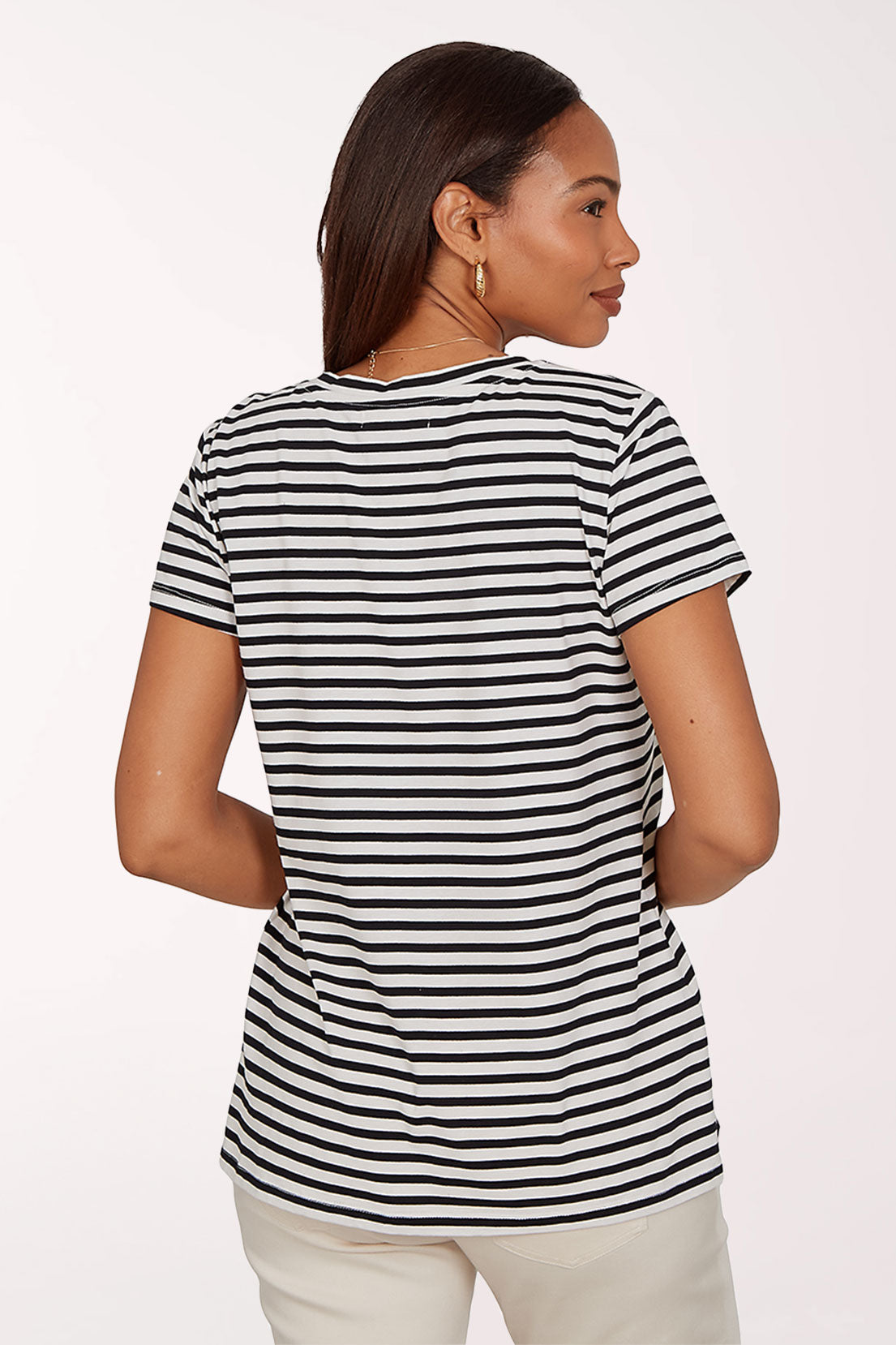 Woman wearing a black and white striped t-shirt with a colorful toucan design on a white background