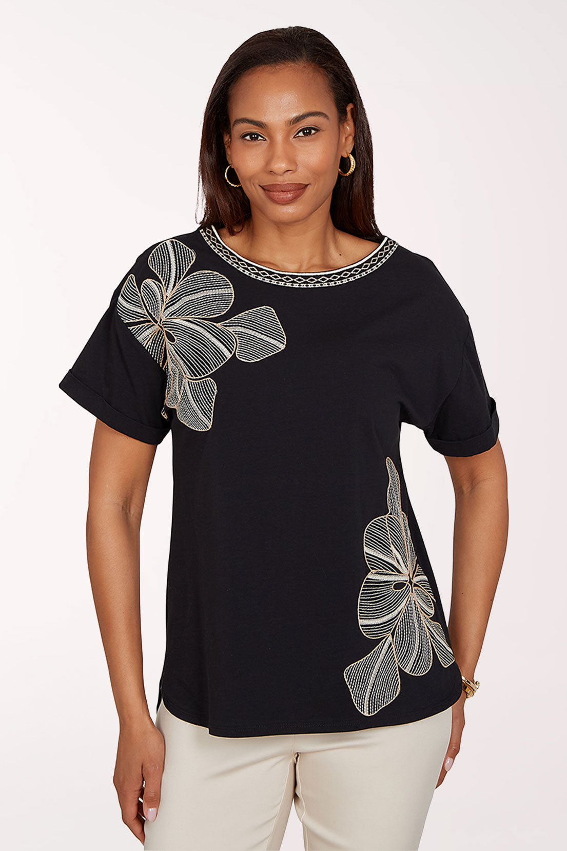 Woman wearing a black top with floral designs on a white background