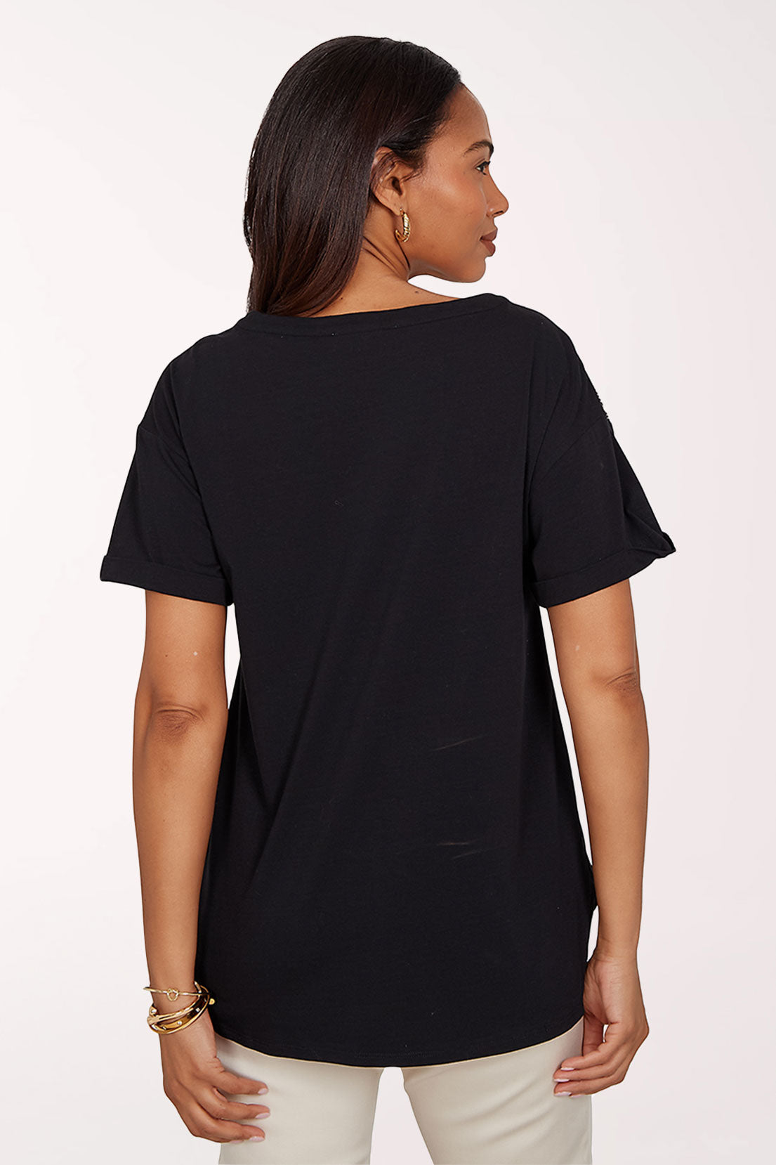 Woman wearing a black top with floral designs on a white background