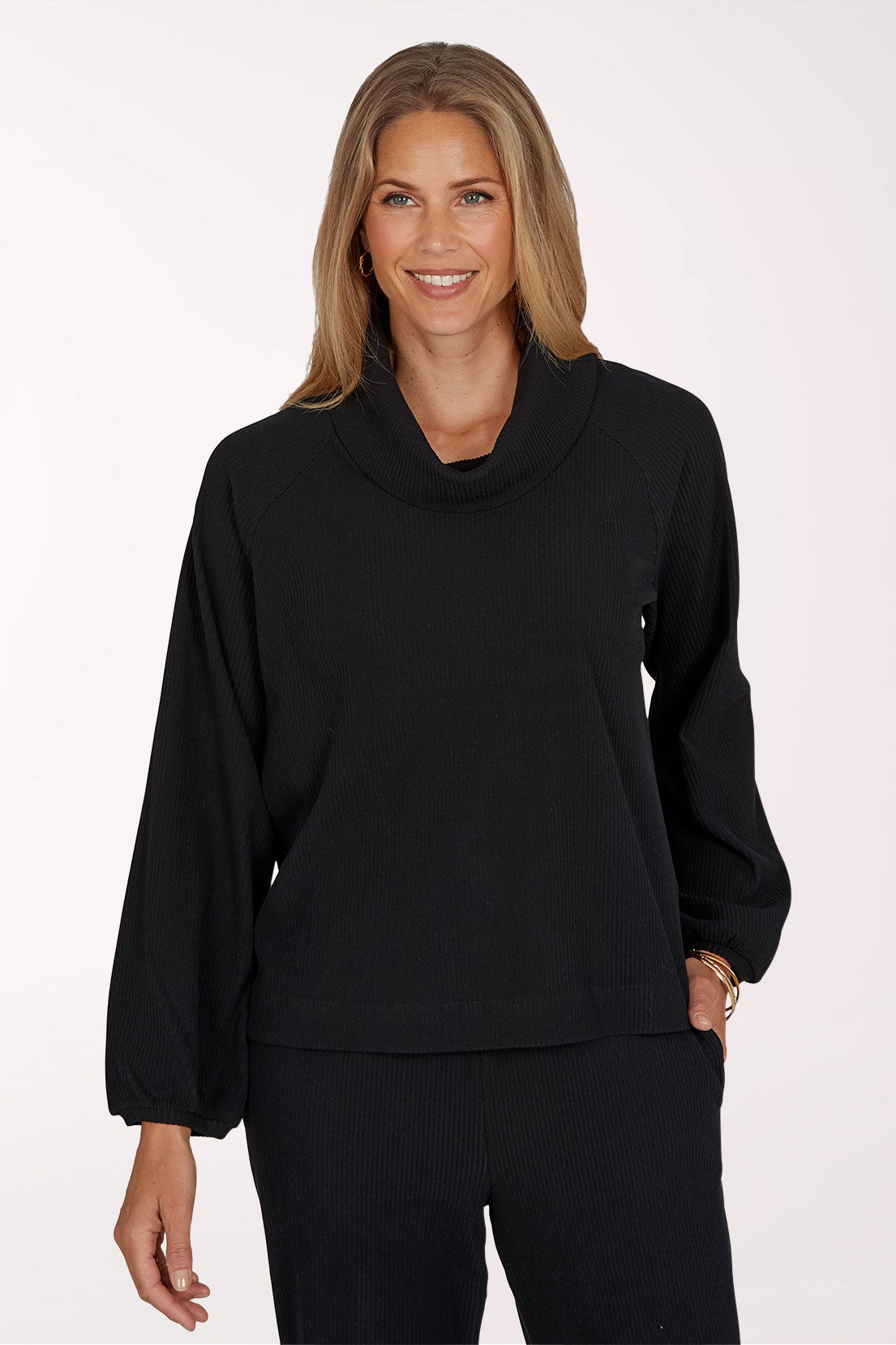 Woman wearing a black long sleeve cowl neck top