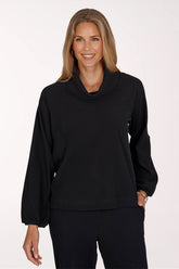 Woman wearing a black long sleeve cowl neck top