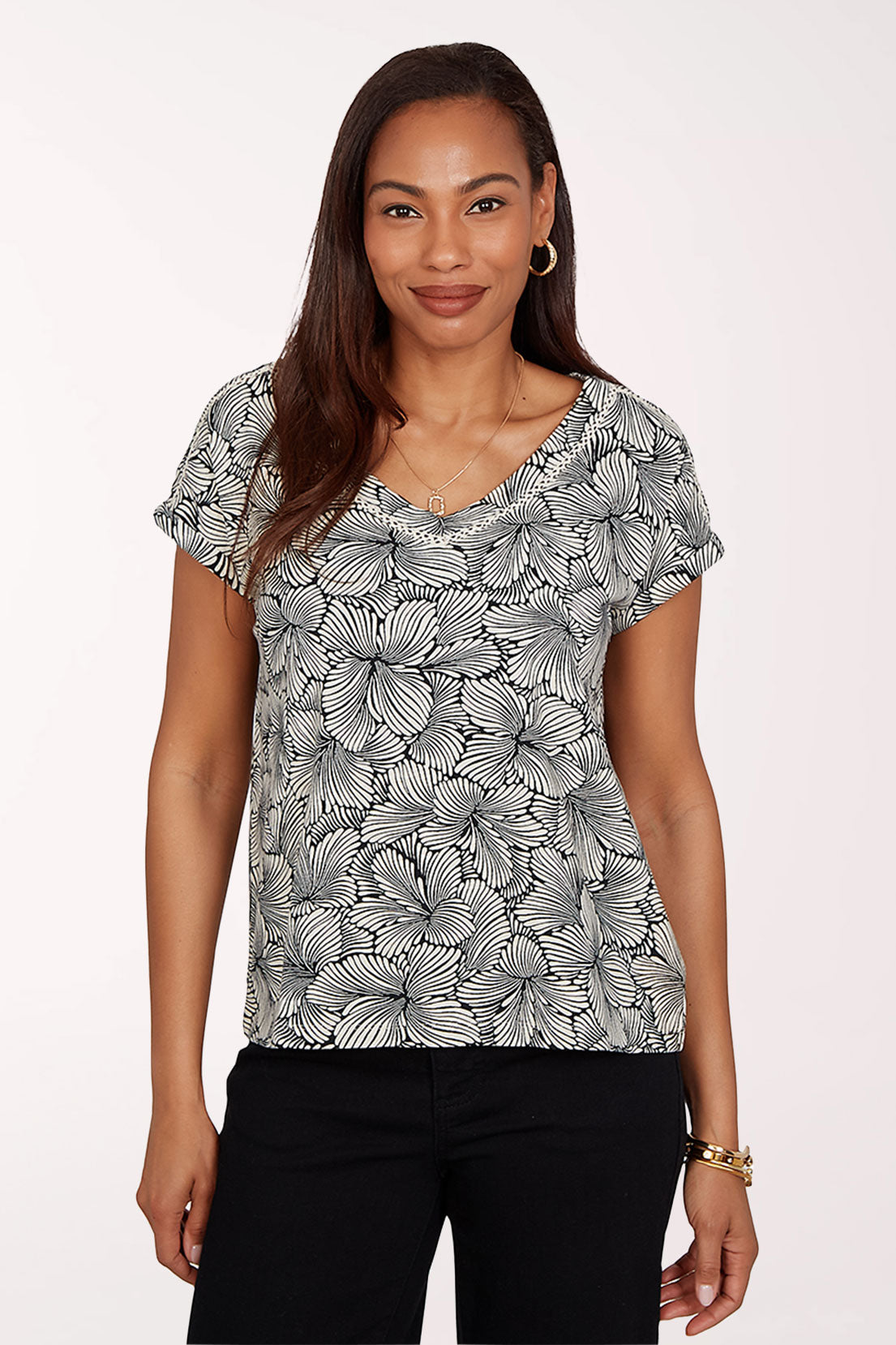 Woman wearing a black and white floral patterned top on a white background