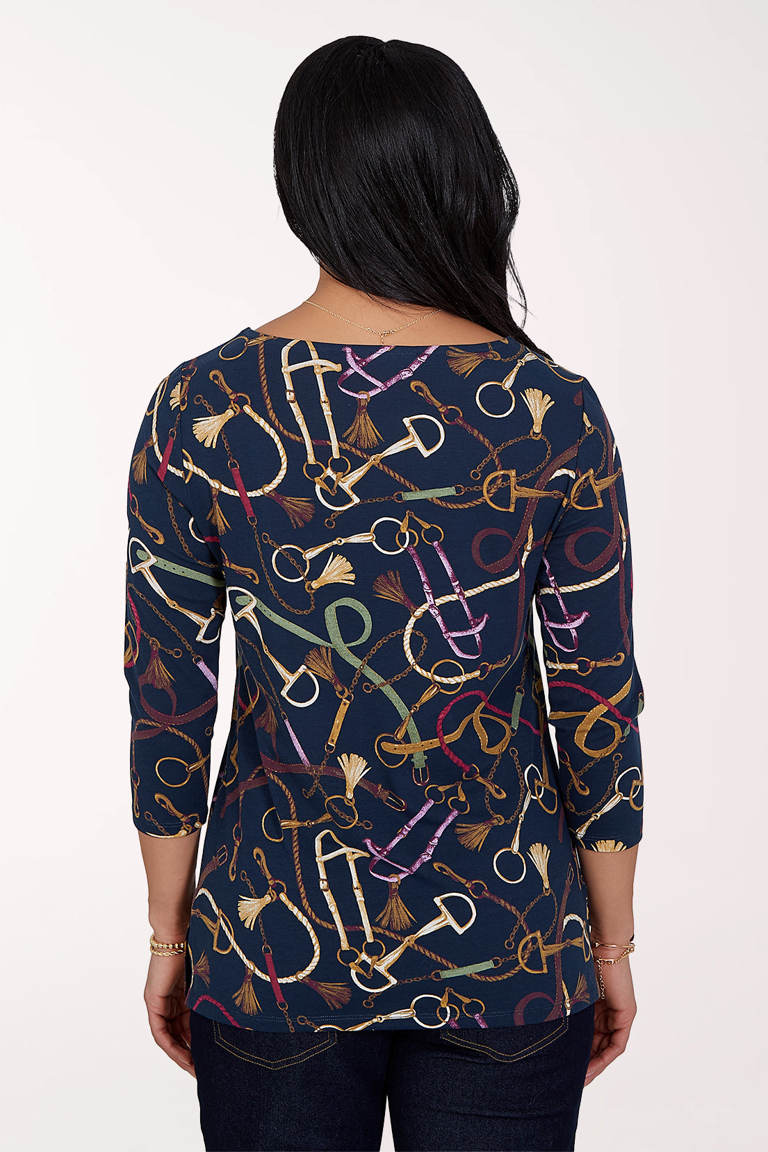 Woman wearing a 3/4 sleeve navy top with an equestrian pattern