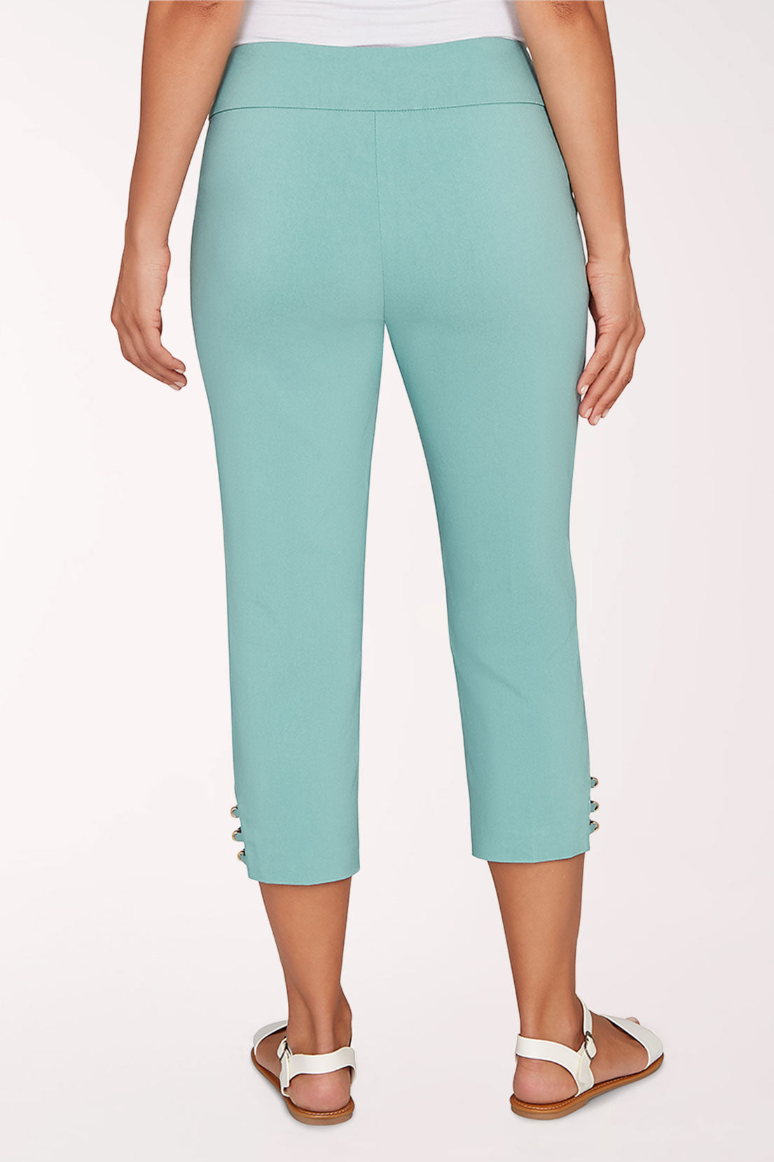 Person wearing teal capri pants on a white background