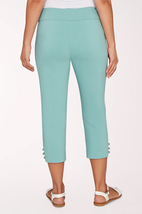 Person wearing teal capri pants on a white background
